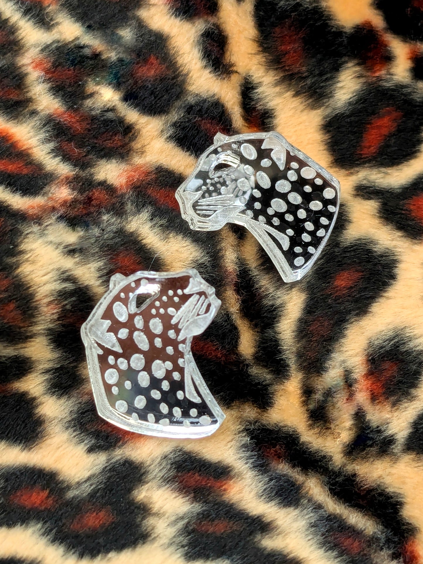 Handmade laser Leopard Heads in Silver Mirrored Acrylic Studs with intricate leopard spot detailing. On a leopard print background